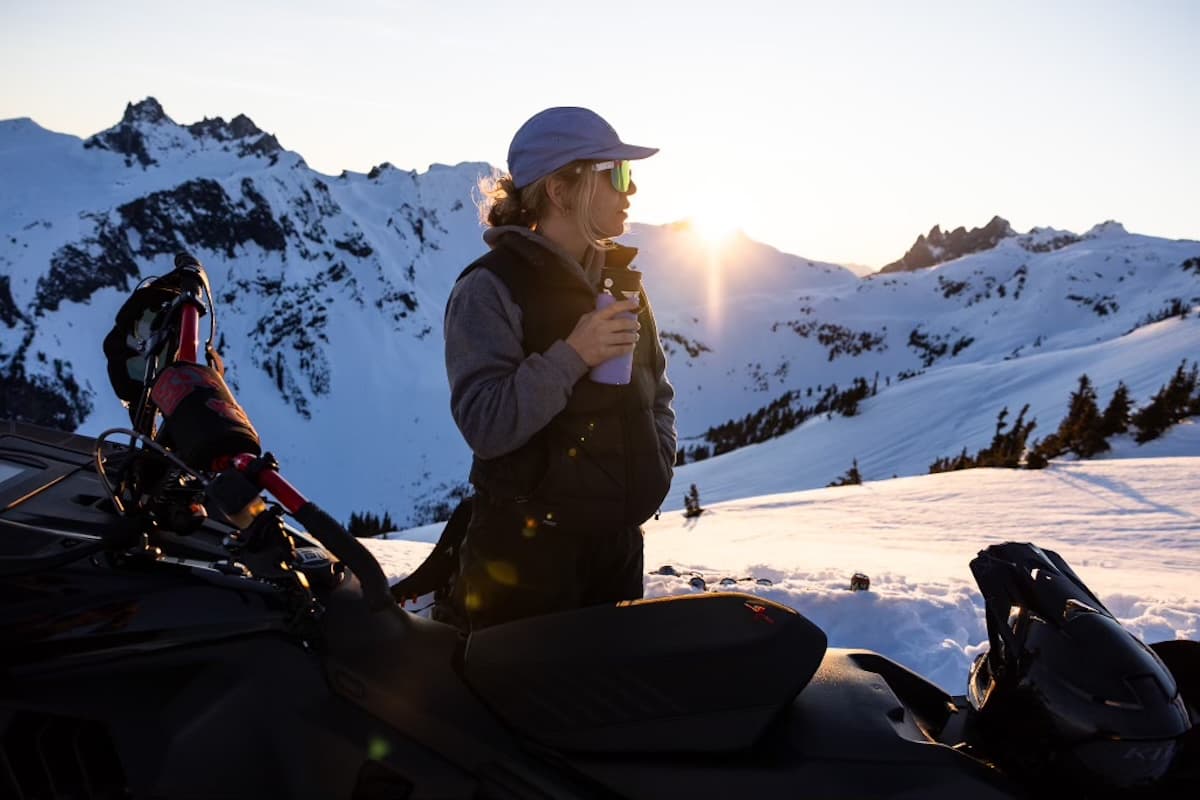 Kaiya on a snowmobile at sunset in the
snowy mountains